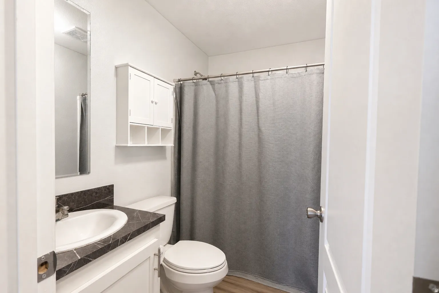 Bathroom featuring vanity, a shower with curtain, and light wood-type flooring