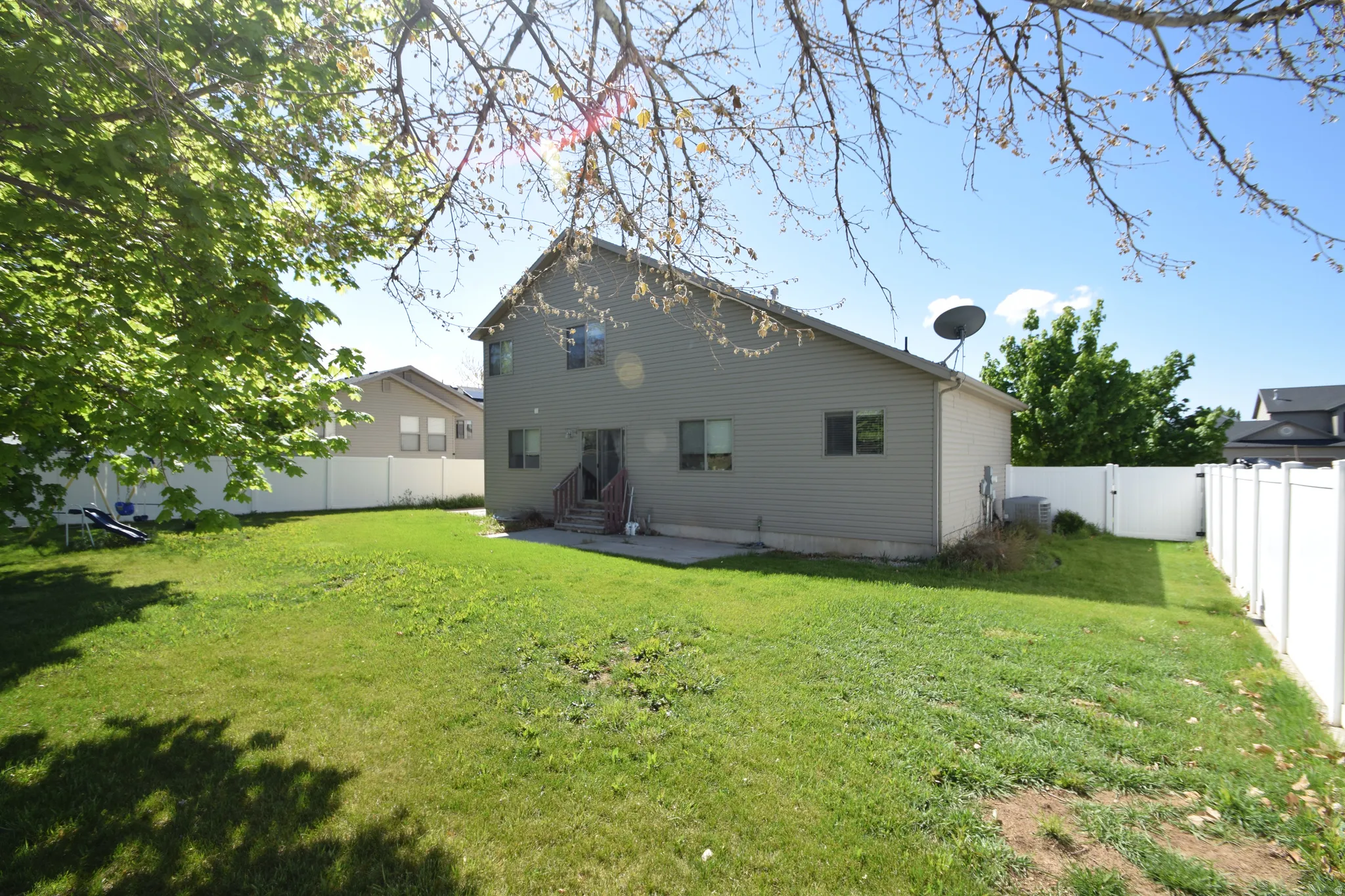 Back of property with a gate, a fenced backyard, a patio, and entry steps