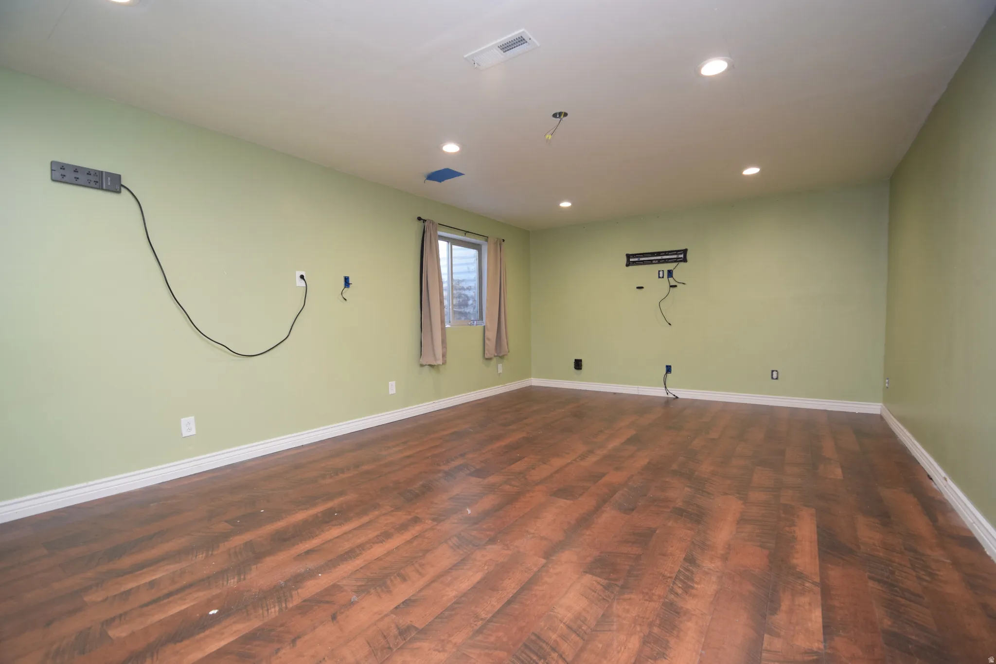 Empty room featuring recessed lighting and dark wood-style flooring