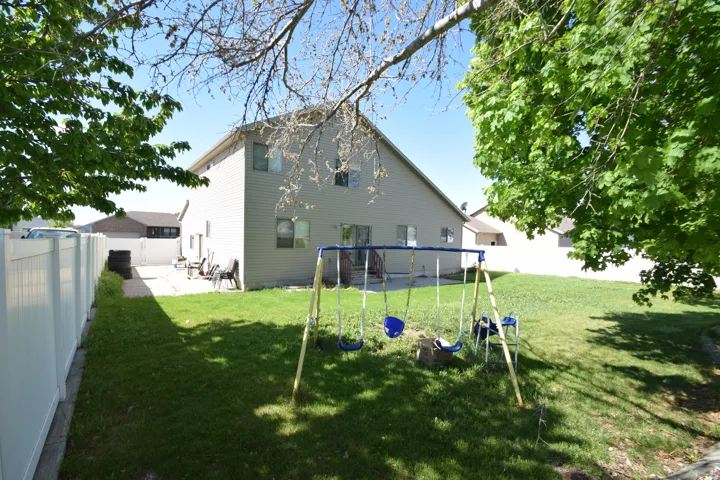 Back of house with a playground and a fenced backyard