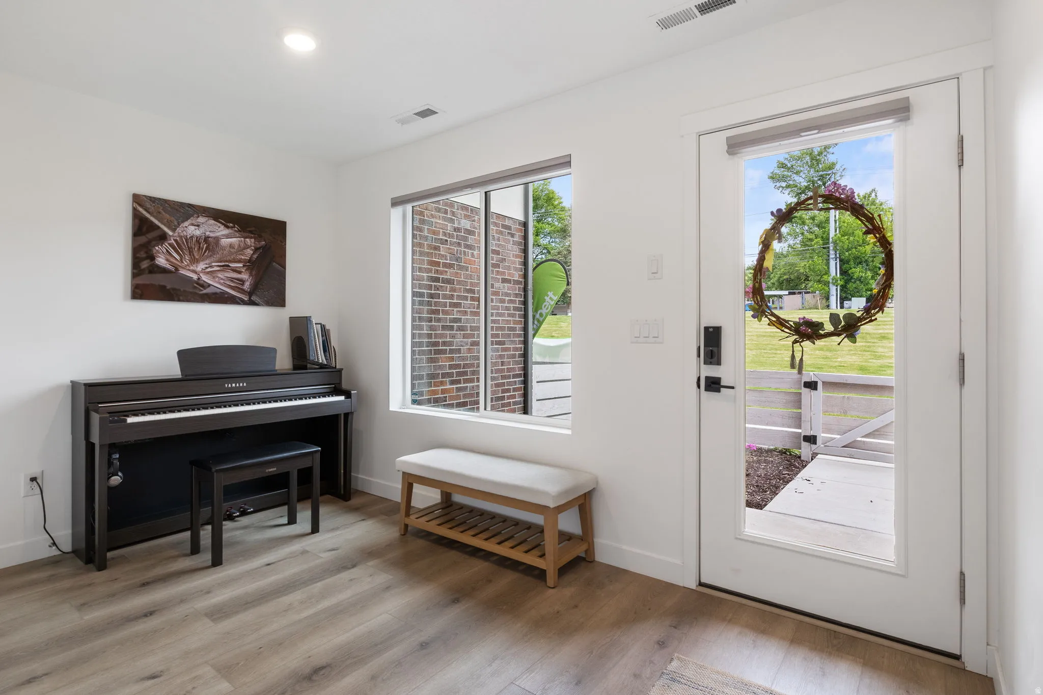 Entry/Den with light wood-style floors and recessed lighting