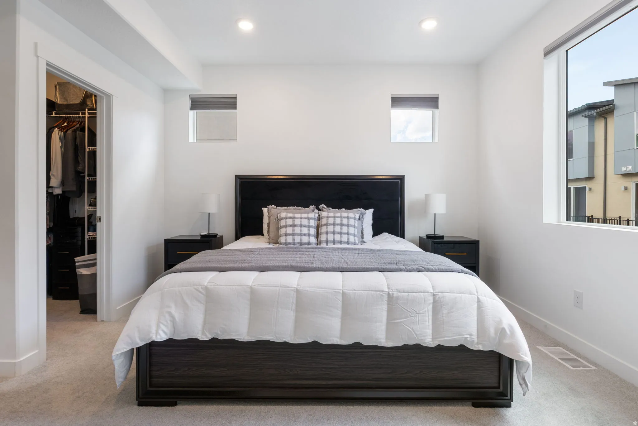 Bedroom featuring recessed lighting, a walk in closet, and light carpet