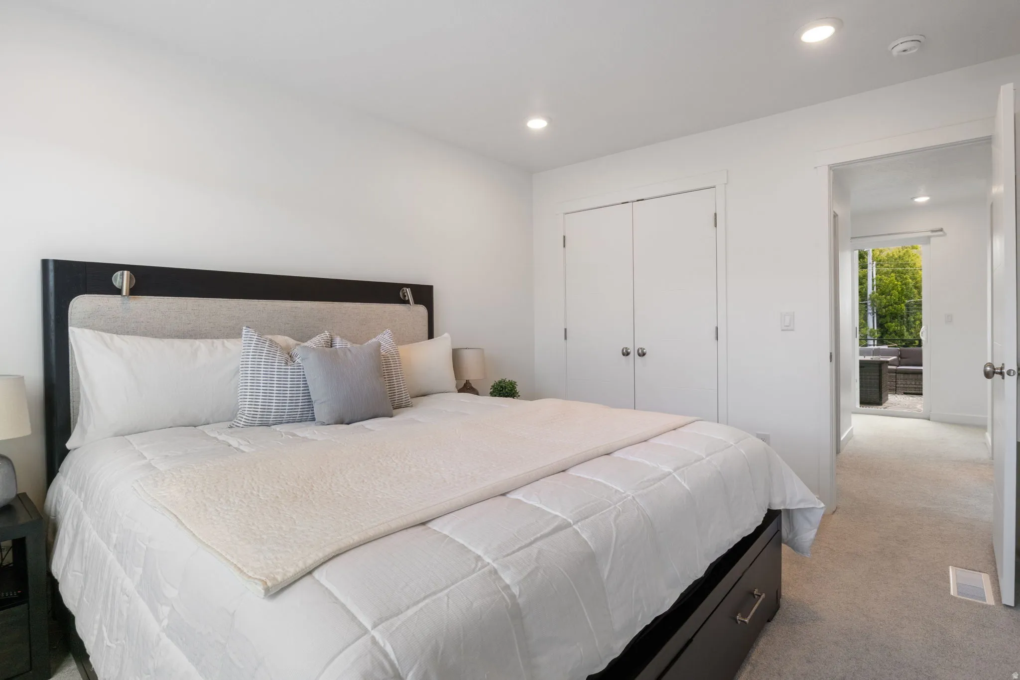 Bedroom featuring a closet, recessed lighting, and light carpet