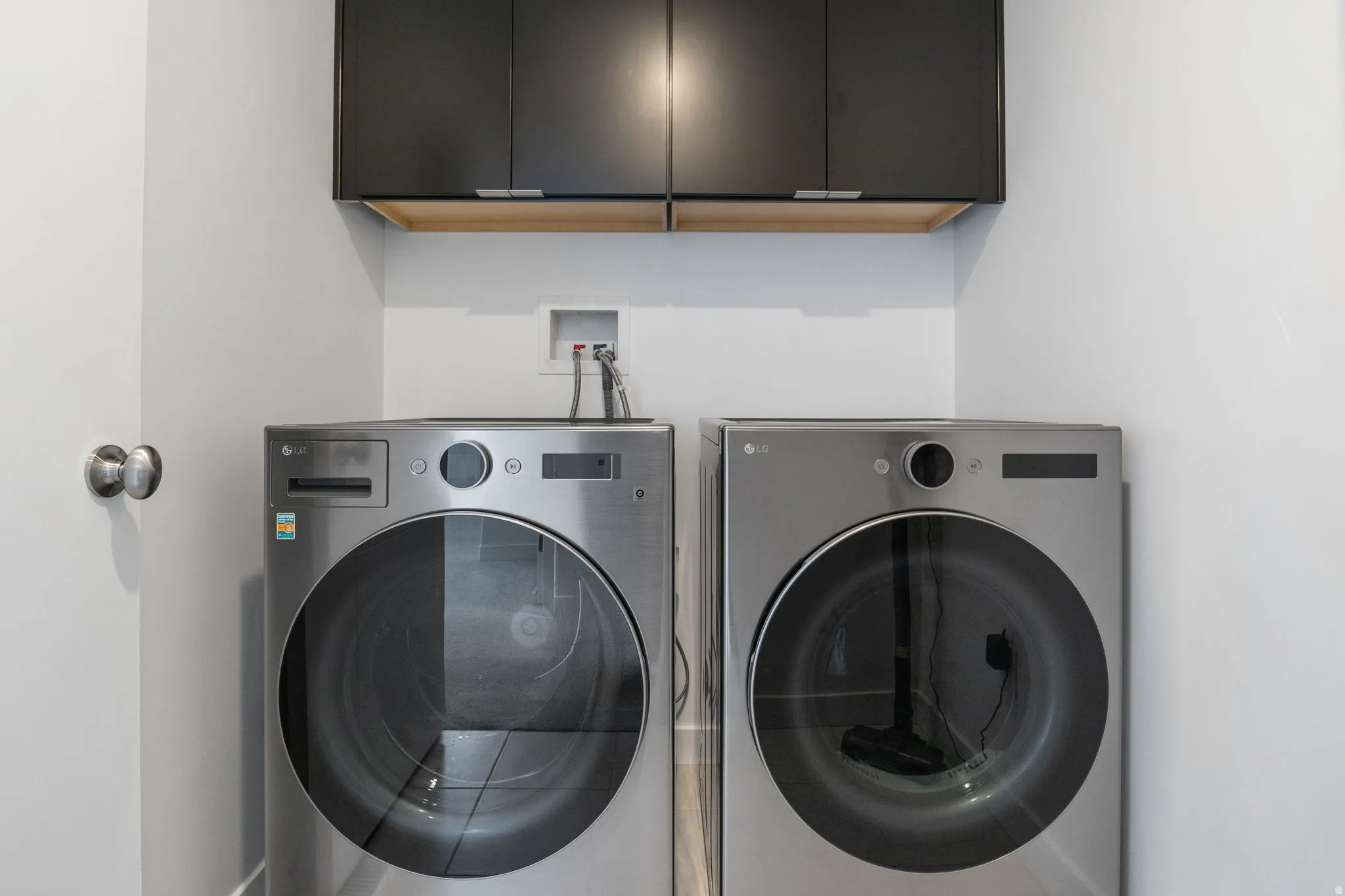 Laundry area with cabinet space and washing machine and clothes dryer