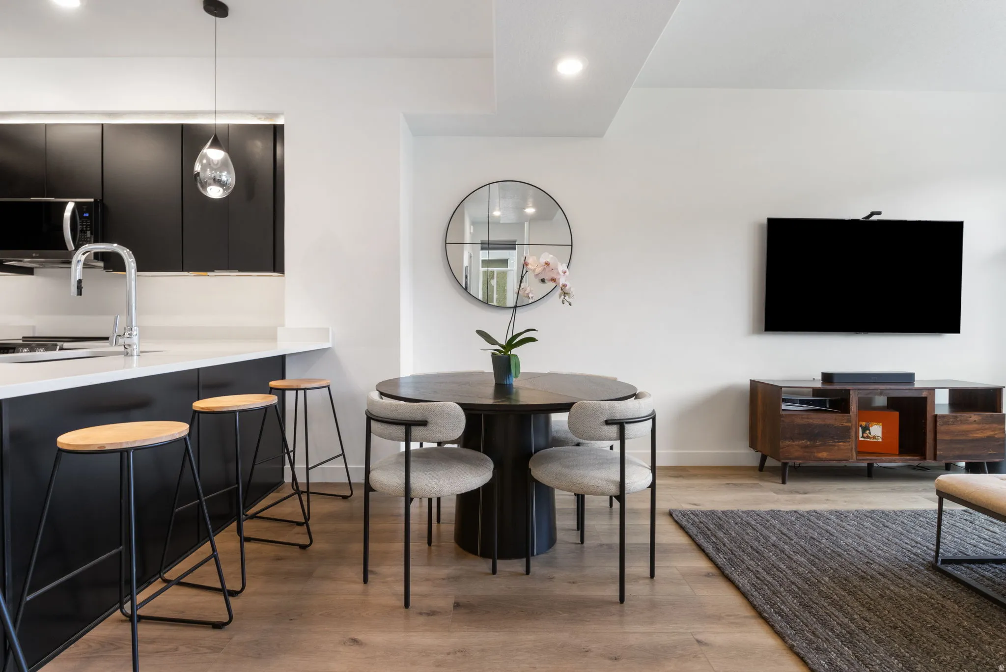 Dining area with light wood finished floors and recessed lighting