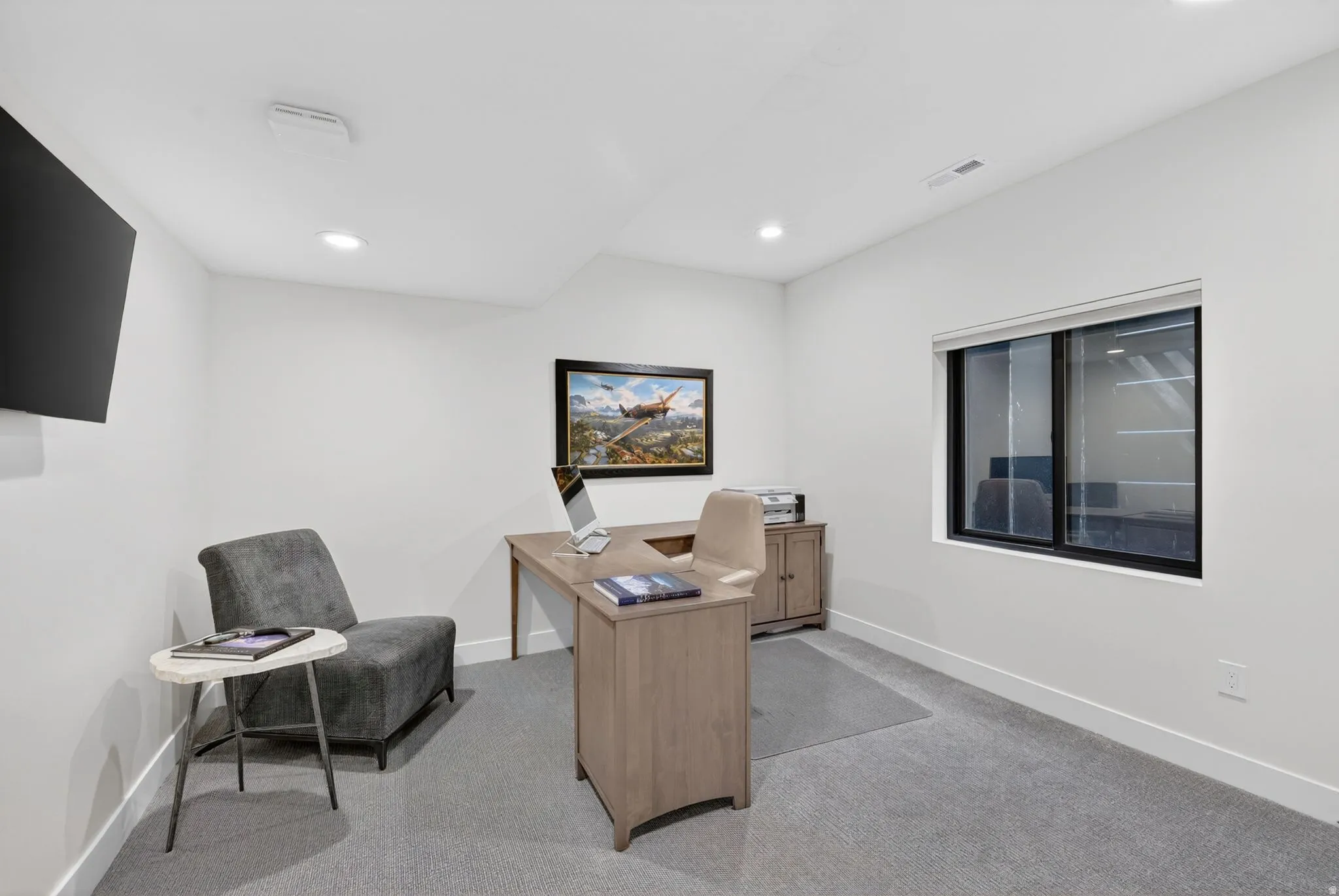 Office or bedroom with light carpet and recessed lighting