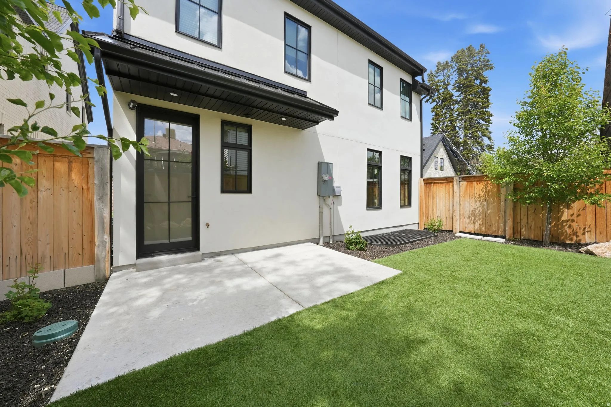 Back of house featuring stucco siding, a fenced backyard, and a patio