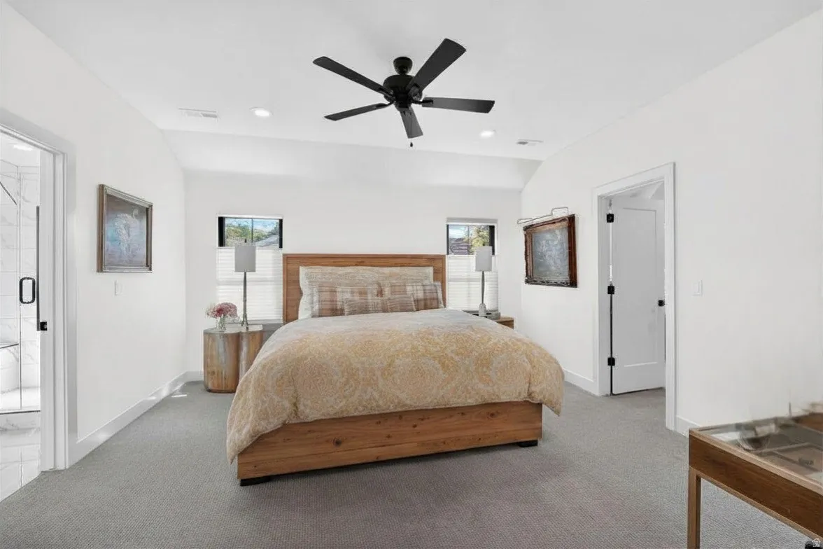 Large primary bedroom featuring lofted ceiling, walk-in closet, carpet, and a ceiling fan