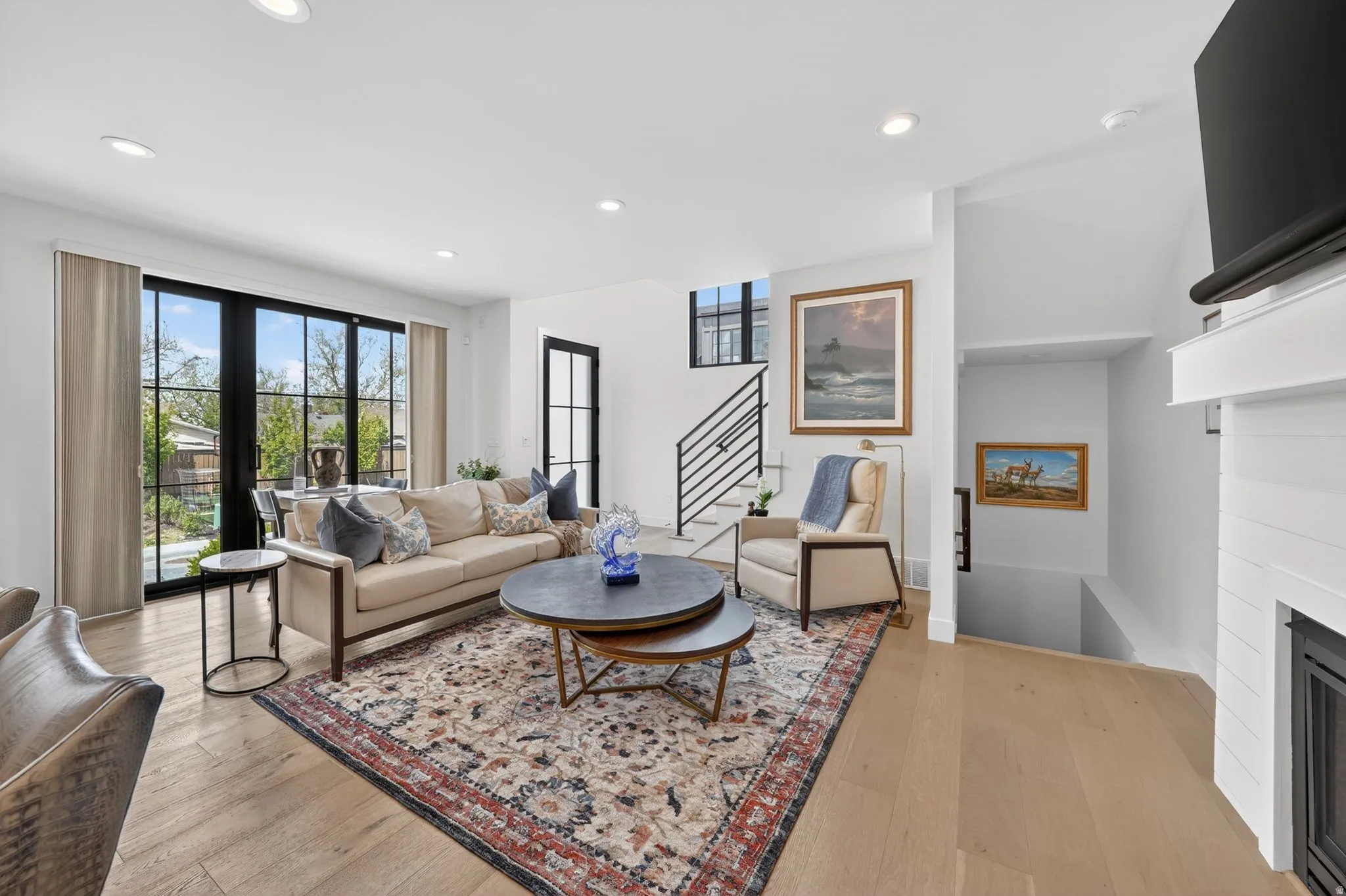 Living area featuring light wood-type flooring, a fireplace, and recessed lighting