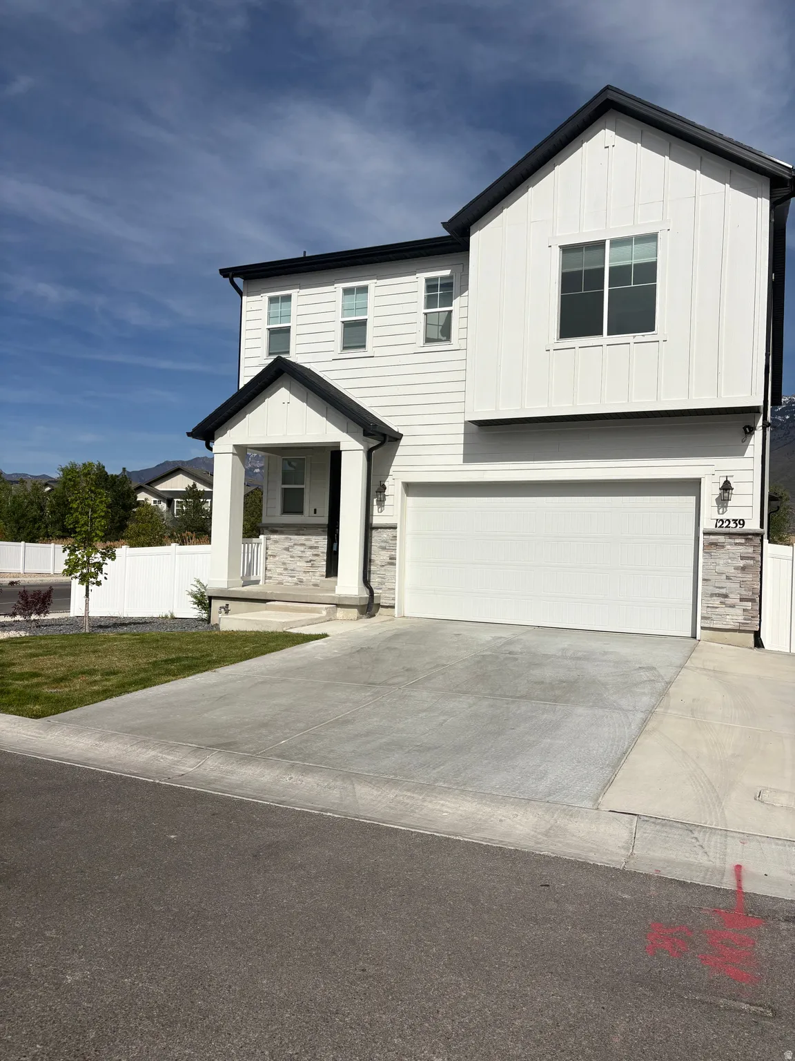 View of front of house featuring board and batten siding, an attached garage, and stone siding