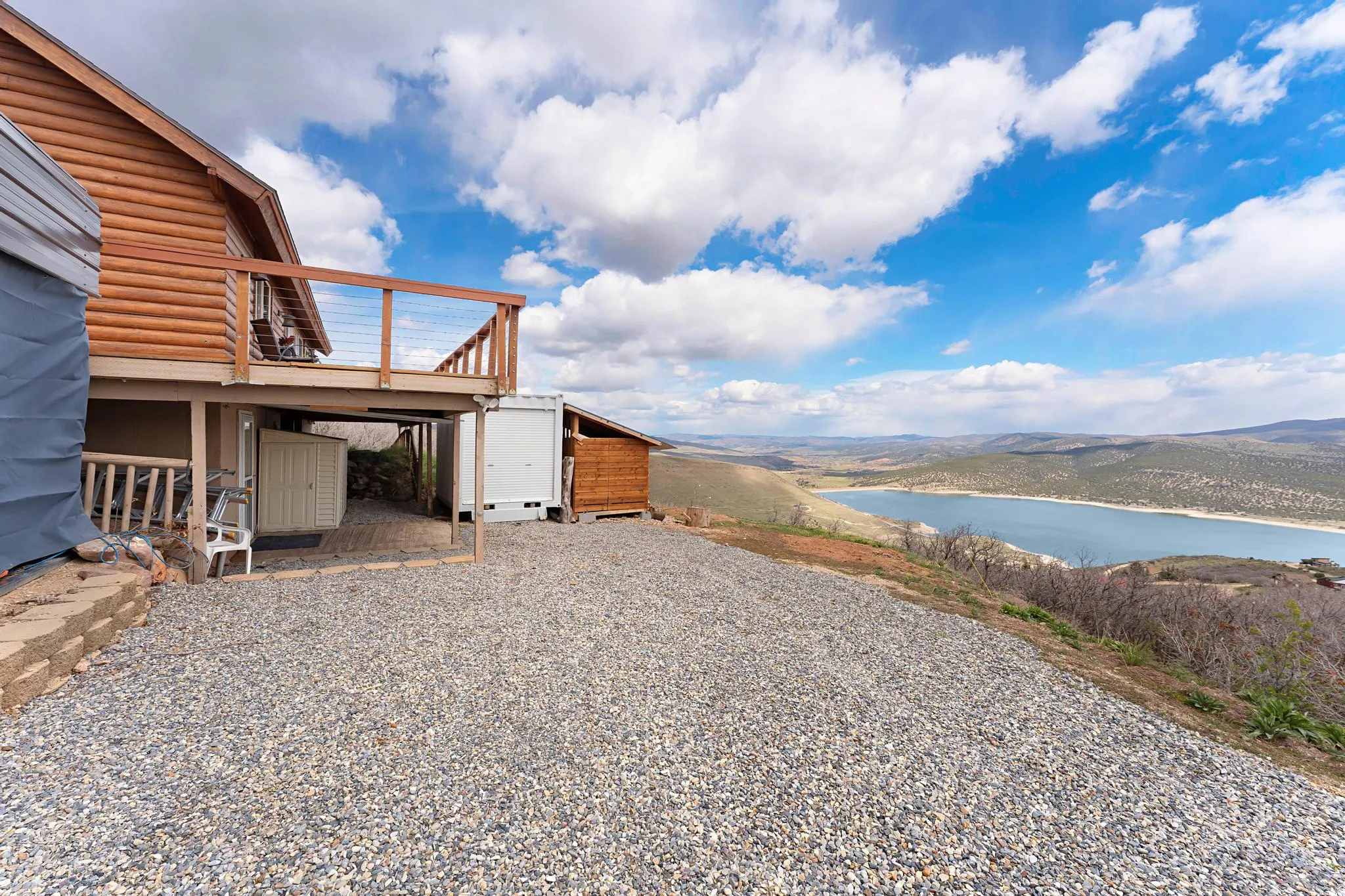 View of yard with a deck with water view and an outdoor structure