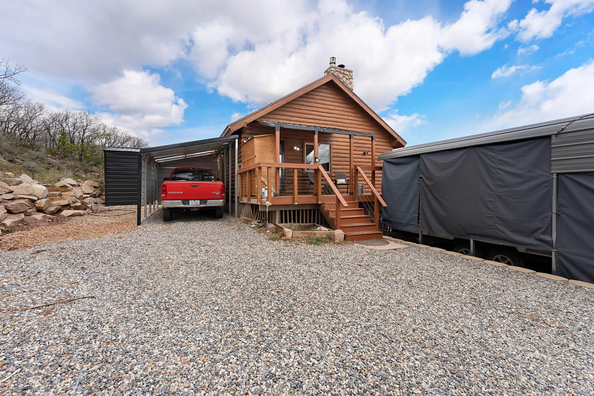 View of outdoor structure with gravel driveway and a carport