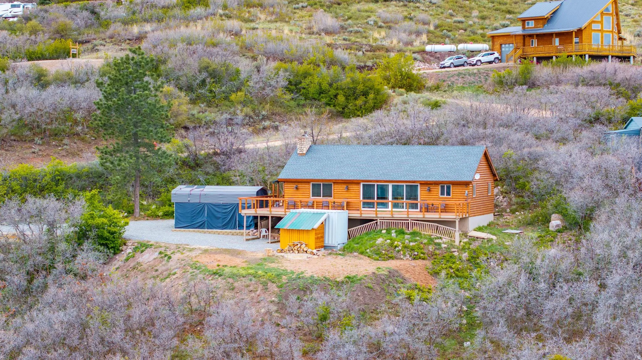 Back of property featuring a wooden deck, log siding, and a chimney