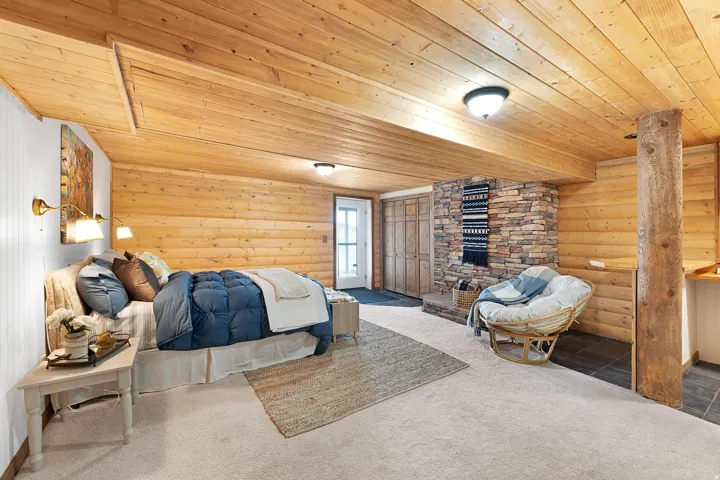 Bedroom featuring log walls, carpet, and wood ceiling