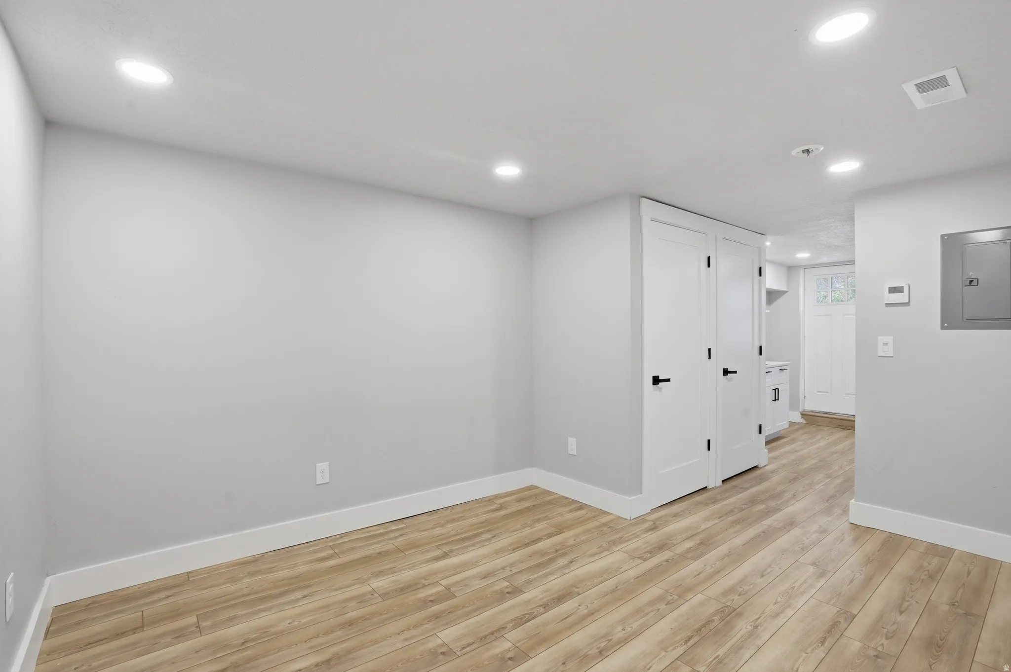 Unit #40 studio apartment with separate entrance. Spare room featuring light wood-style floors, recessed lighting, and electric panel