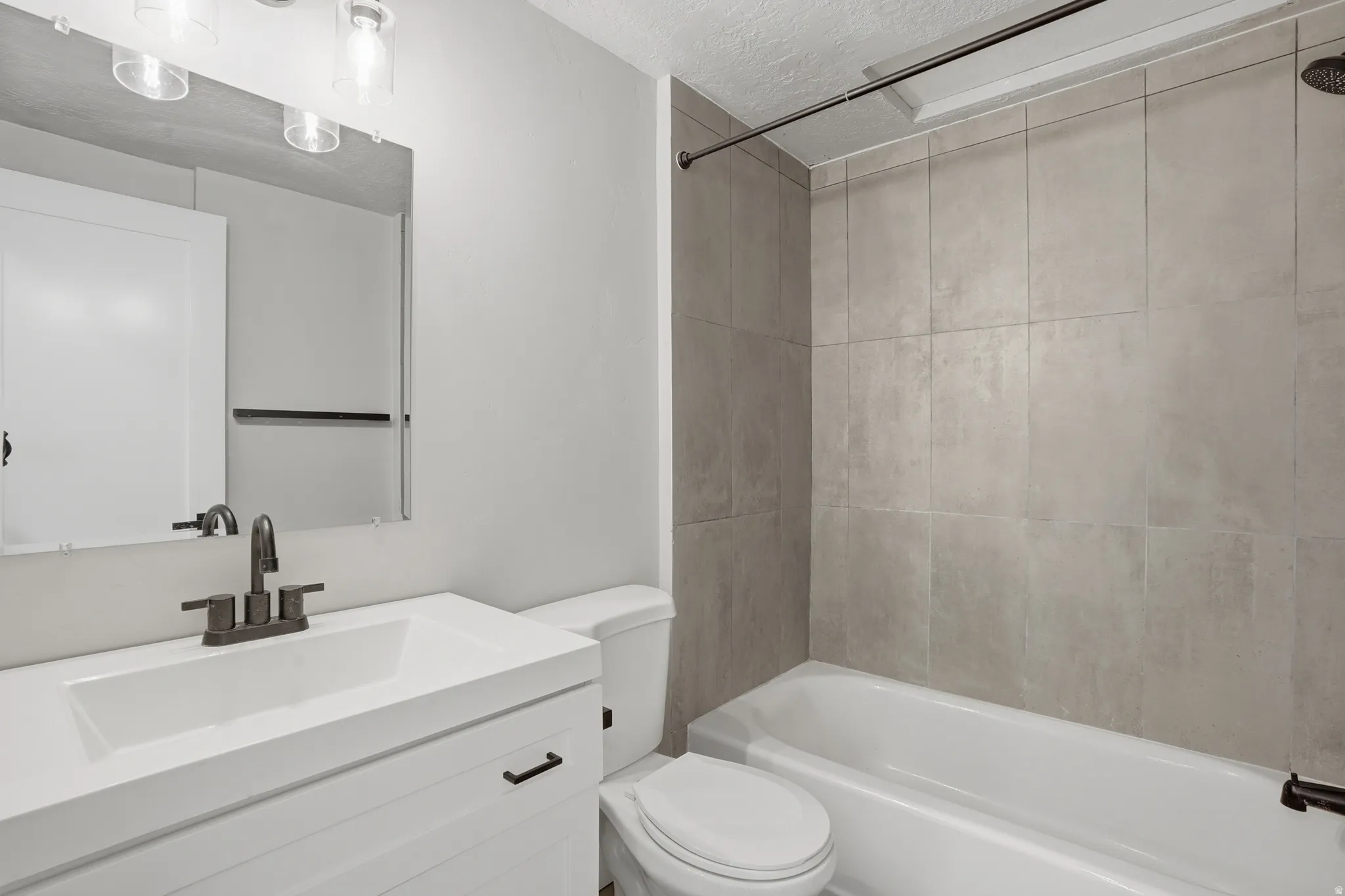 Unit #40 Bathroom with vanity, a textured ceiling, and bathing tub / shower combination