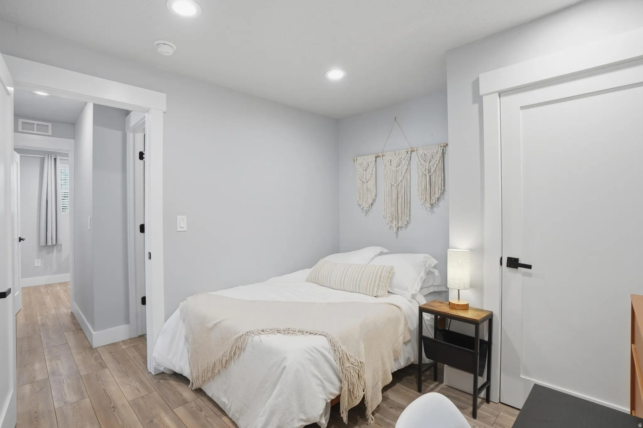 Furnished Unit #44 faces West. Bedroom featuring light wood finished floors and recessed lighting
