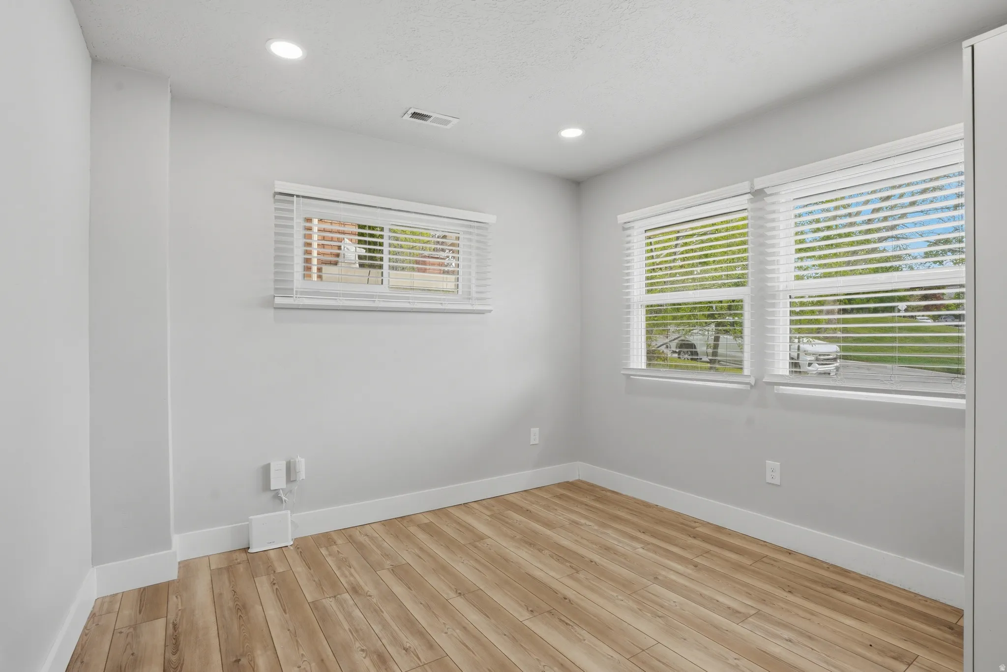 Unit #40 Empty room featuring light wood finished floors and recessed lighting