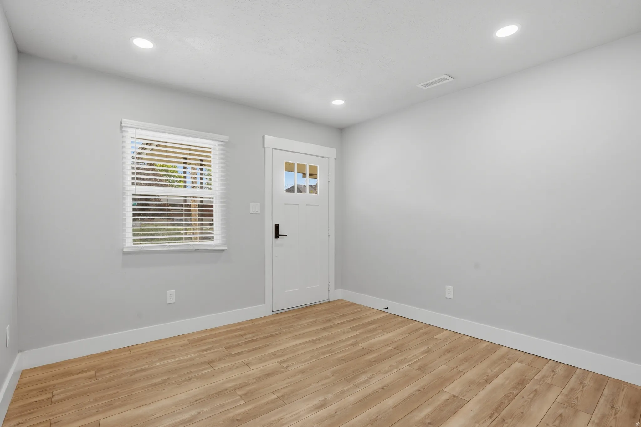 Unit #40 Foyer with light wood-style flooring and recessed lighting