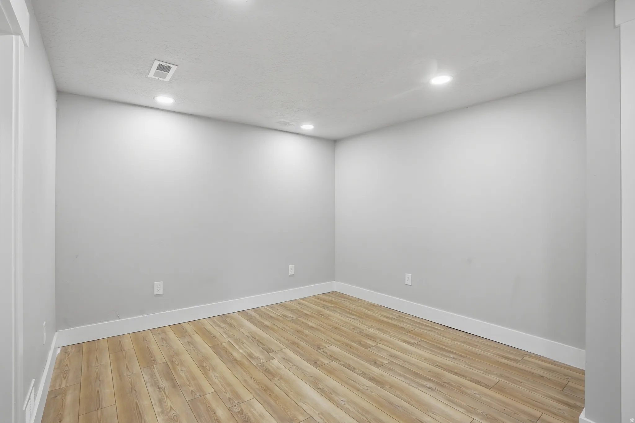 Unit #40 studio apartment with separate entrance.Empty room featuring light wood-type flooring and recessed lighting