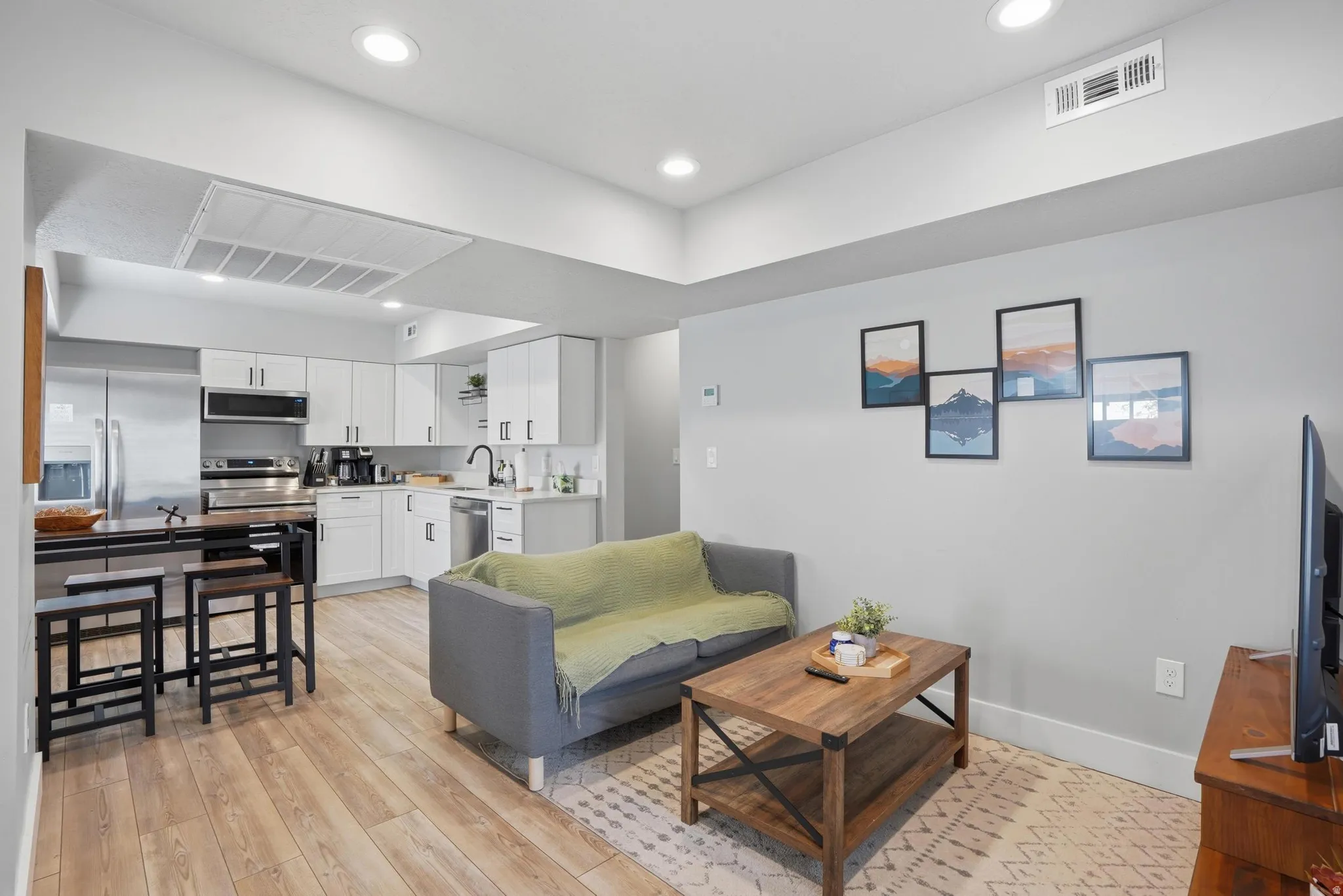 Furnished Unit #44 faces West. Living room featuring light wood-style flooring and recessed lighting