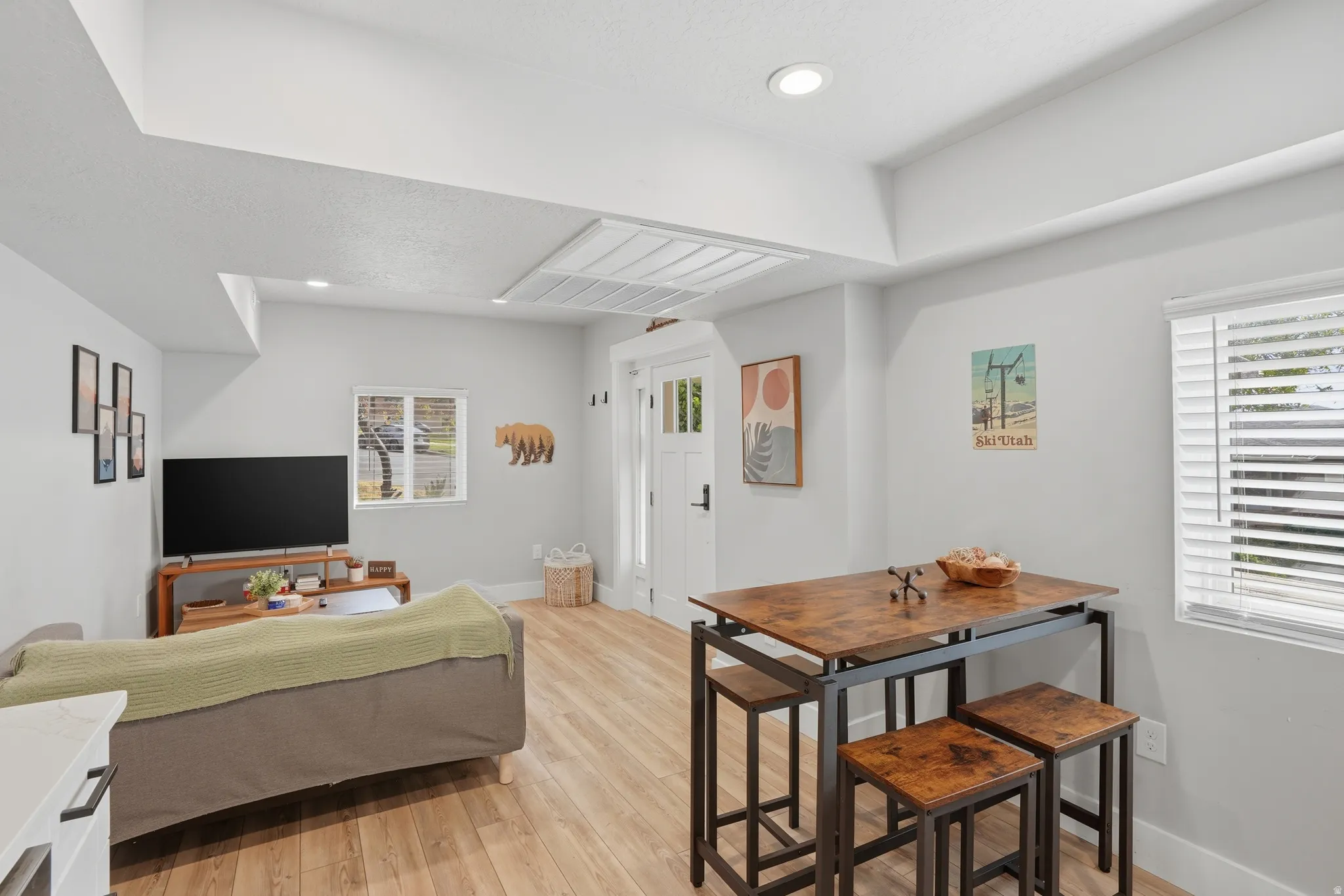 Furnished Unit #44 faces West. Living area featuring light wood-style flooring and recessed lighting
