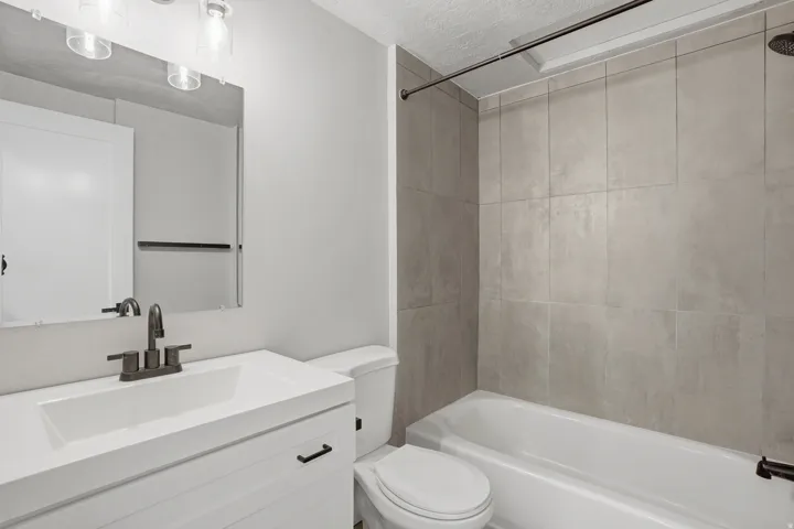 Unit #40 Bathroom with vanity, a textured ceiling, and bathing tub / shower combination