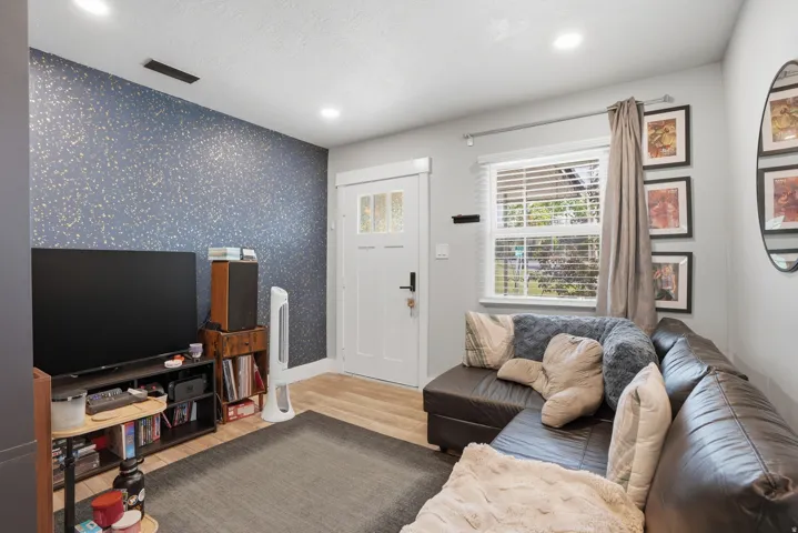 Unit #42 Living area with wallpapered walls, an accent wall, light wood finished floors, and recessed lighting