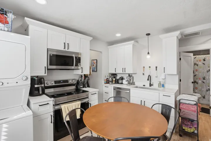 Unit #42 Kitchen featuring stainless steel appliances, light countertops, and white cabinetry