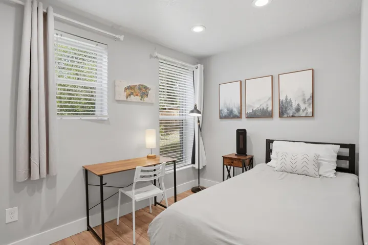 Furnished Unit #44 faces West. Bedroom featuring light wood-style flooring and recessed lighting
