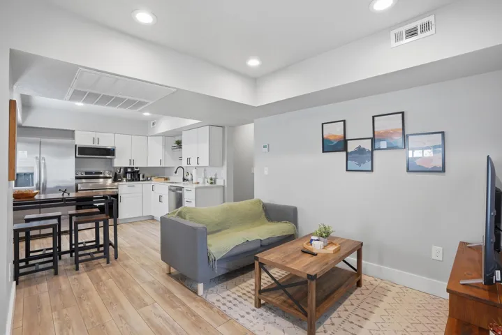 Furnished Unit #44 faces West. Living room featuring light wood-style flooring and recessed lighting