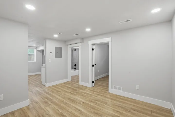 Unit #40 studio apartment with separate entrance. Unfurnished room with recessed lighting, light wood-type flooring, and electric panel