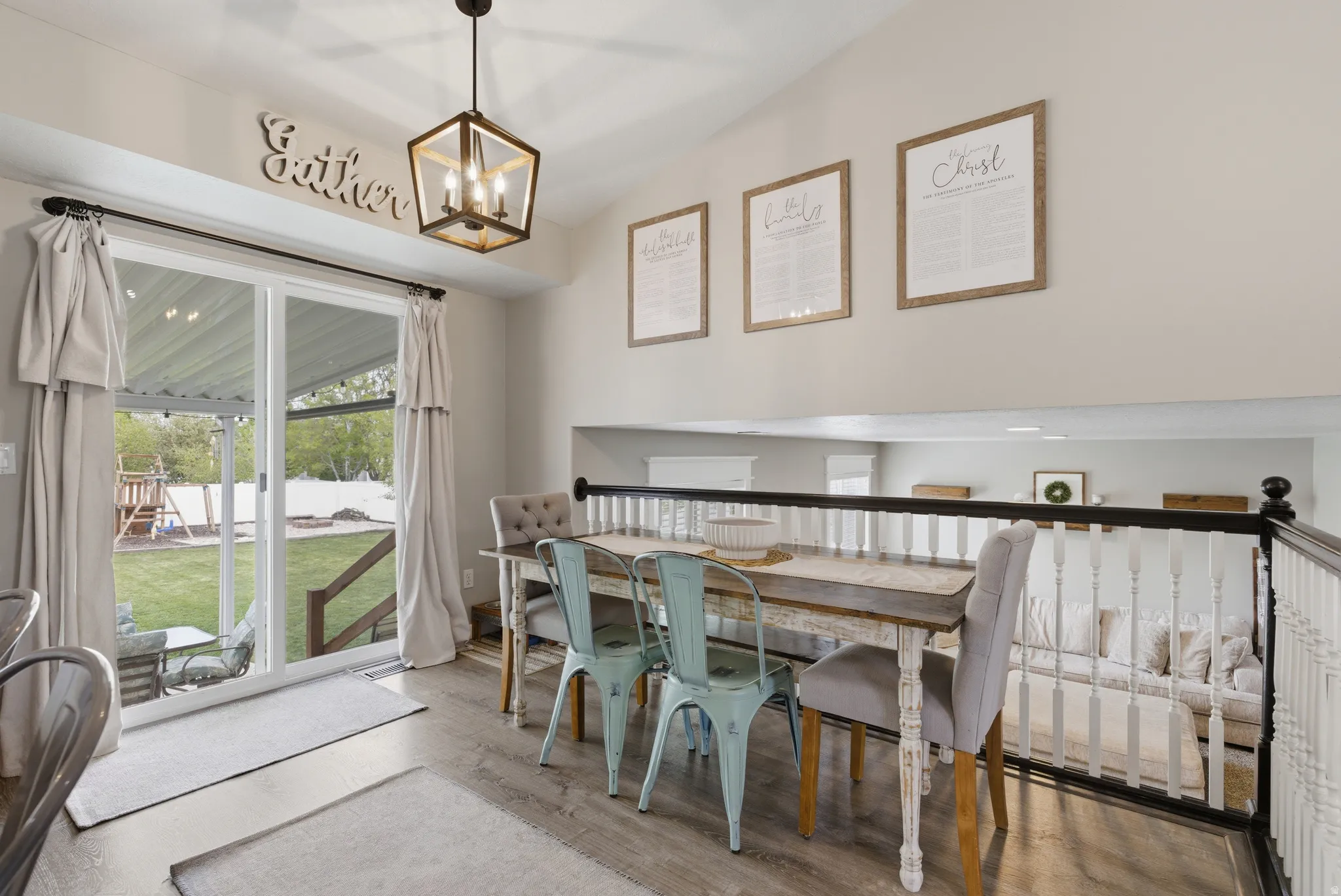 Dining space with light wood-type flooring, vaulted ceiling, and a chandelier
