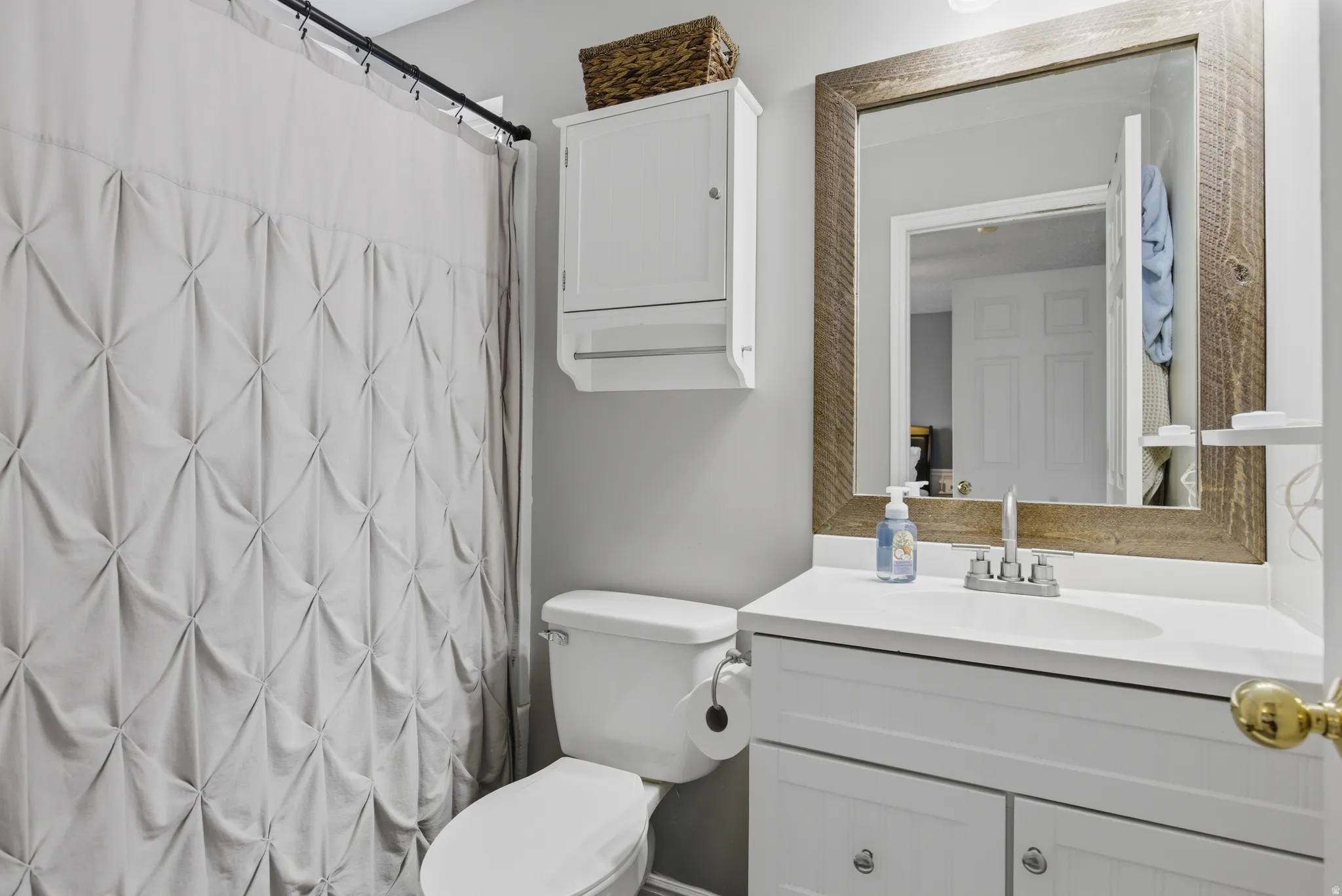 Bathroom with a shower with shower curtain and vanity