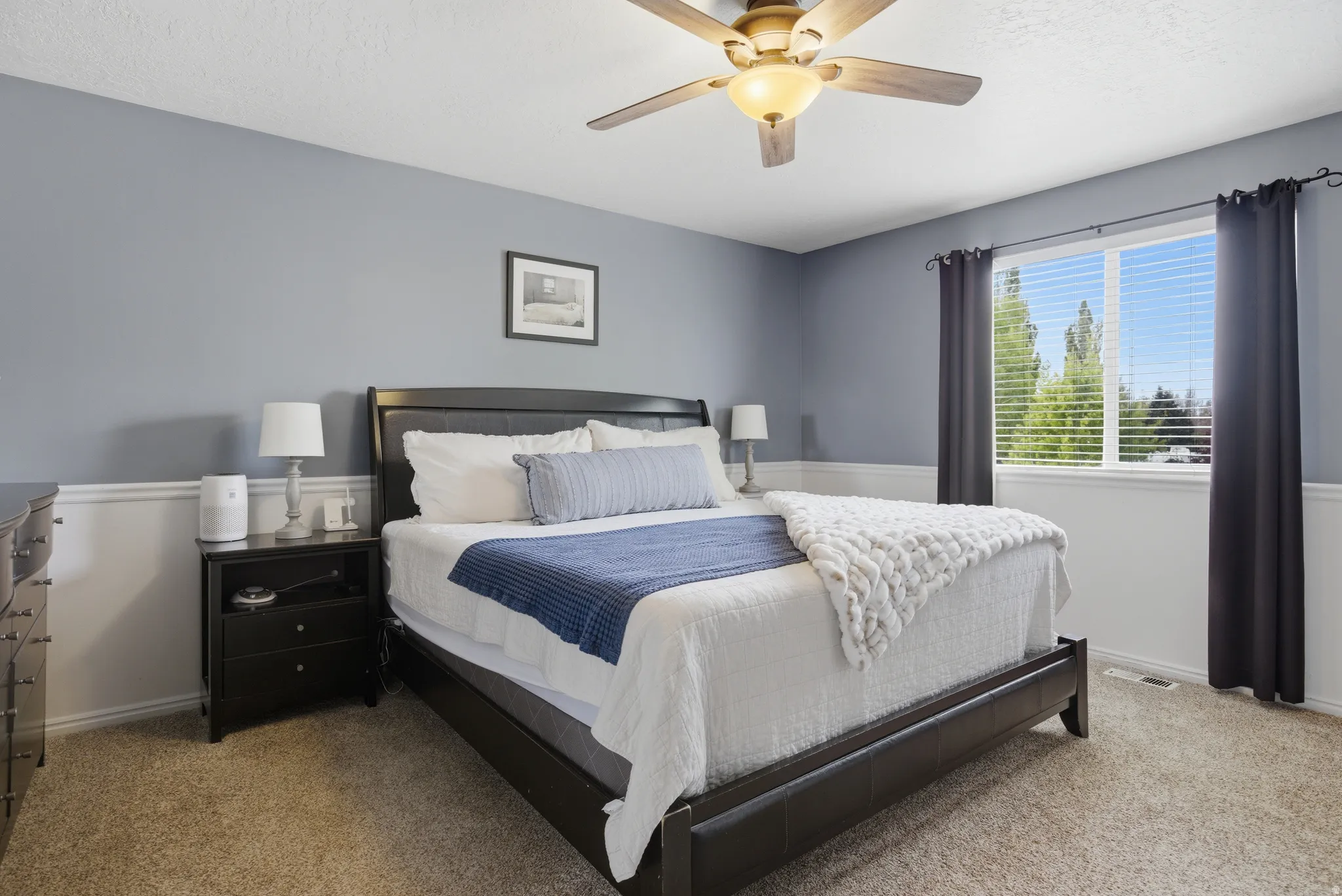 Bedroom with light carpet and a ceiling fan