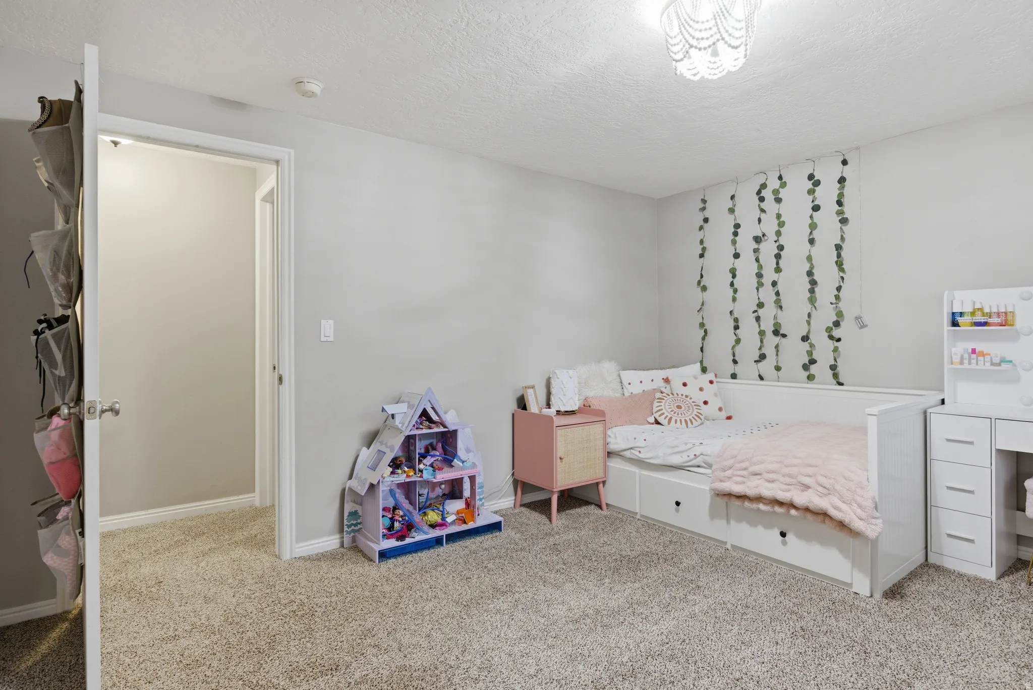 Bedroom with light colored carpet and a textured ceiling