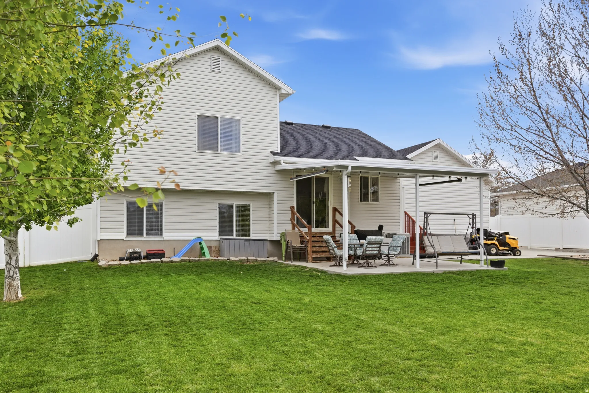 Back of property with a patio area, entry steps, and roof with shingles