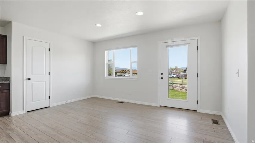 Unfurnished dining area with light wood-style floors and recessed lighting