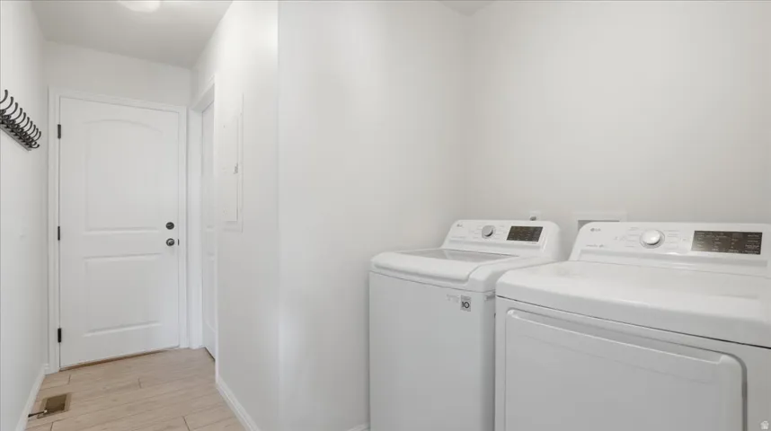 Laundry area featuring washer and dryer and light wood-style floors