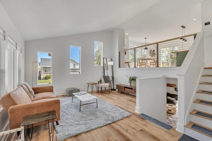 Living room with lofted ceiling, plenty of natural light, light wood-type flooring, and recessed lighting