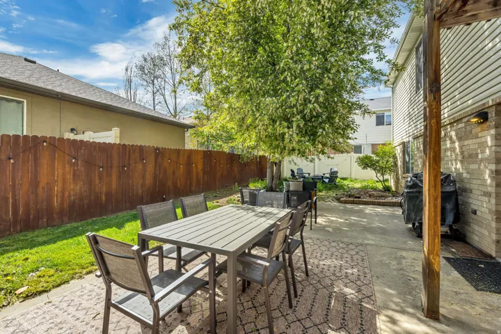 Fenced backyard with a patio, outdoor dining space, and grilling area