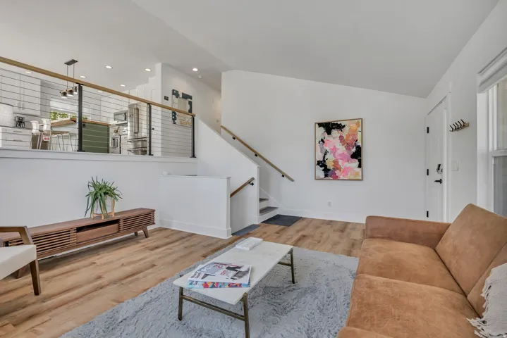 Living room with light wood-style flooring, lofted ceiling, and recessed lighting