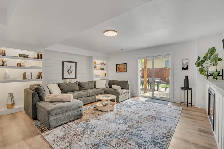 Living area featuring light wood-type flooring, built in shelves, and a fireplace