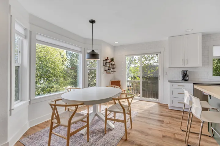 Dining area with light wood finished floors and recessed lighting