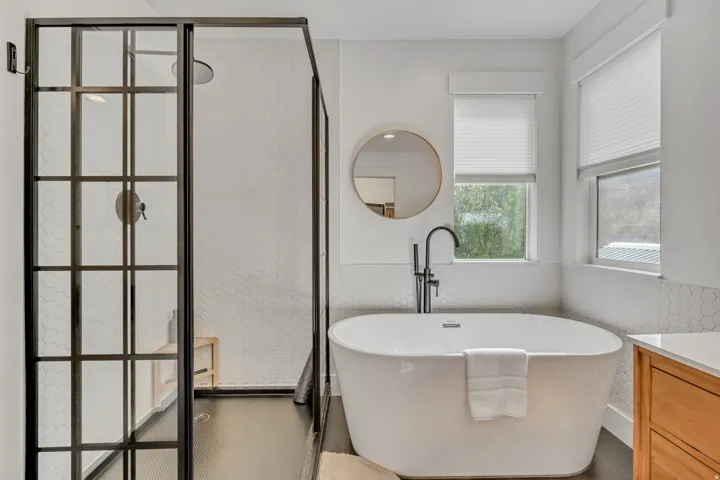 Bathroom with vanity, a freestanding tub, and walk in shower