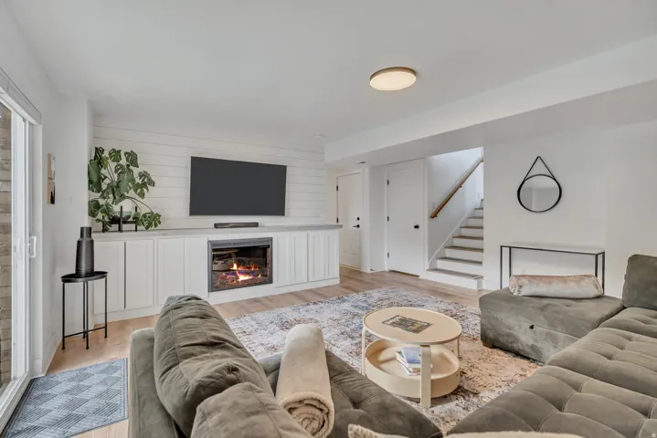 Living area featuring light wood finished floors and a glass covered fireplace