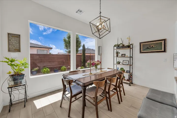 Dining space with wood finish floors and suspended lighting