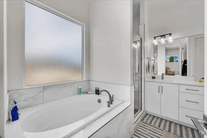 Full bathroom with vanity, a garden tub, and a shower stall