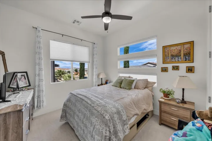Bedroom featuring a ceiling fan and light colored carpet