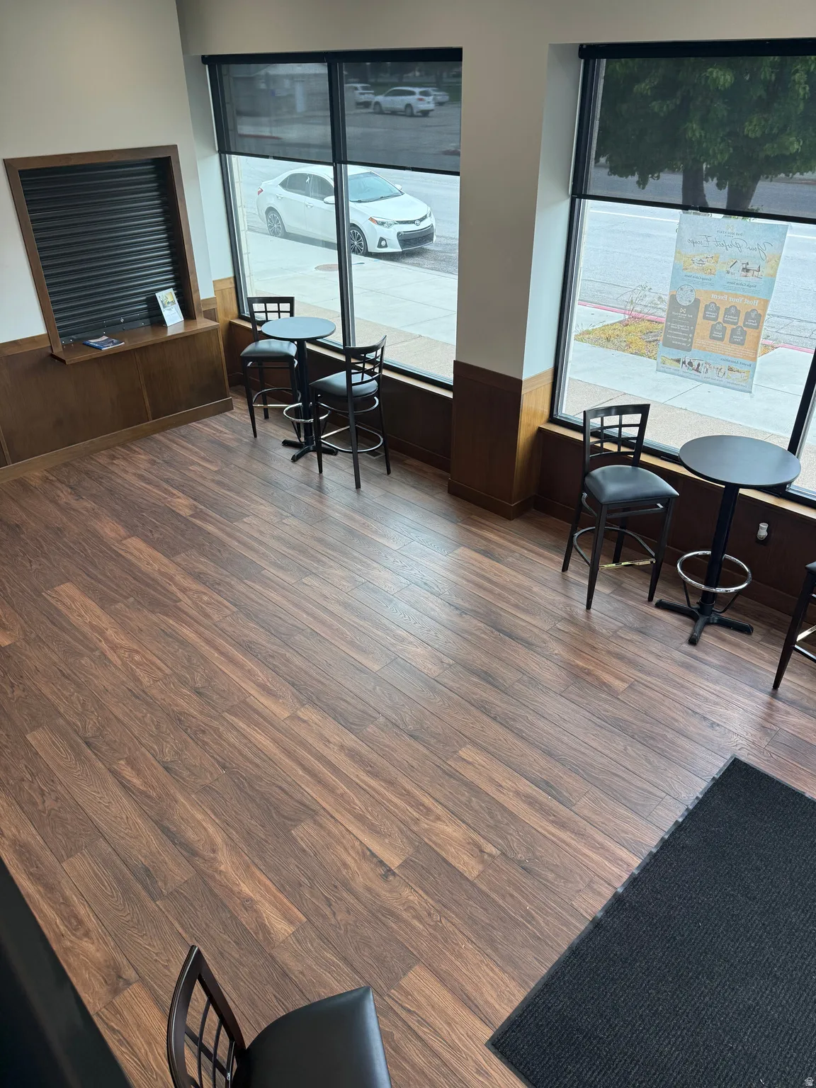 Dining area featuring wainscoting, wooden walls, and dark wood-style flooring